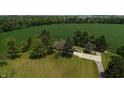 Aerial view of property showing home with mature landscaping and large cultivated field to the north at 2000 Hawthorne Dr, Plainfield, IN 46168
