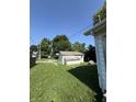 Backyard features a detached shed, overgrown grass, and view of the home's siding at 2215 Noble St, Anderson, IN 46016