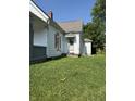 Side view of a single Gathering home, showing peeling paint and a green lawn at 2215 Noble St, Anderson, IN 46016