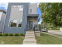Inviting front door with modern design, concrete stairs, and a sleek black railing at 2326 Prospect St, Indianapolis, IN 46203