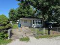 Cozy single-story home with a fenced yard and mature trees offering shade, ideal for a quiet neighborhood setting at 2354 Collier St, Indianapolis, IN 46241