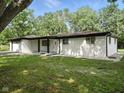 Charming exterior of a one-story home featuring a well-maintained lawn and mature trees at 2853 S State Ave, Indianapolis, IN 46203