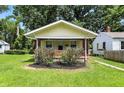 Inviting bungalow with a covered porch, manicured bushes, and a well-kept lawn at 3609 N Keystone Ave, Indianapolis, IN 46218
