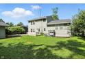 Spacious backyard with a large lawn, mature trees, and a cozy swing for relaxation at 4023 N Arlington Ave, Indianapolis, IN 46226