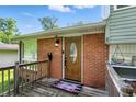 Inviting front entrance with a decorative wood door, brick surround, and a charming welcome mat at 4023 N Arlington Ave, Indianapolis, IN 46226