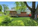 Attractive two-story home with a brick lower level, wood siding, and lush front yard at 4023 N Arlington Ave, Indianapolis, IN 46226