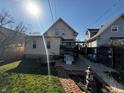 View of backyard, showcasing the home's exterior, grassy area, and partially covered patio at 429 Wallace Ave, Indianapolis, IN 46201