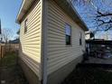 Exterior home detail featuring vinyl siding, well-maintained drainage, and a glimpse of the backyard at 429 Wallace Ave, Indianapolis, IN 46201