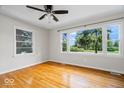 Bright living room with hardwood floors and large windows overlooking a lush yard at 5407 Adelaide St, Indianapolis, IN 46203