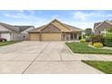 Beautiful single-story home with a spacious driveway, manicured lawn, and brick facade at 5659 Augusta Woods Dr, Plainfield, IN 46168
