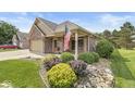 Well-maintained home with a brick facade, an American flag, and landscaped front yard at 5659 Augusta Woods Dr, Plainfield, IN 46168