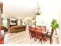 Open-concept dining area with natural light, adjacent to the living room and kitchen with wood-style flooring at 5765 White Pine Rd, Whitestown, IN 46075