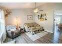 Cozy living room with hardwood floors, neutral paint, ceiling fan, and a comfortable seating arrangement at 740 Springmill Dr, Mooresville, IN 46158