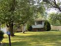 Charming home featuring a well-maintained lawn and mature trees framing the front yard at 9138 E 18Th St, Indianapolis, IN 46229