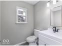 Clean bathroom features a white vanity, modern fixtures, and a window for natural light at 9665 Gull Lake Dr, Indianapolis, IN 46239