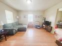 Inviting living room with hardwood floors, sofa, media center and view to dining area at 1002 S Fleming St, Indianapolis, IN 46241