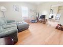 Bright living room featuring hardwood floors, a comfortable sofa, and plenty of natural light at 1002 S Fleming St, Indianapolis, IN 46241