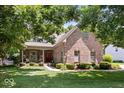 Charming brick home with a cozy front porch and a well-manicured lawn surrounded by mature trees at 10381 Beaver Ridge Dr, Fishers, IN 46037