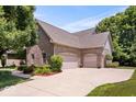 Spacious three-car garage with brick exterior and well-maintained landscaping along a wide driveway at 10381 Beaver Ridge Dr, Fishers, IN 46037