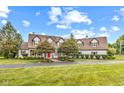 Sprawling two-story home featuring a red front door, mature trees, and a pristine lawn at 10594 Geist Rd, Fishers, IN 46037