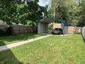 Spacious backyard featuring a car port, fenced perimeter, and lush green grass at 1125 N Rural St, Indianapolis, IN 46201