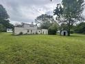 Rear exterior view of the home with a large backyard and mature trees at 1330 Schleicher Ave, Indianapolis, IN 46229