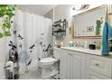 Well-lit bathroom featuring white vanity, decorative mirror, and shower with floral curtain at 1346 N Buck Creek Rd, Greenfield, IN 46140