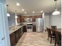 Modern kitchen featuring stainless steel appliances, granite countertops, and stylish wood-look flooring at 1706 Creekwater Pass, Greenfield, IN 46140