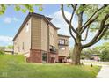 The modern home is complemented by lush greenery and a large shade tree at 2130 Brookside Pkwy N Dr, Indianapolis, IN 46201