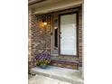 Charming front door with brick surround and flower planter, creating a welcoming entrance at 2411 N Willow Way, Indianapolis, IN 46268