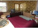 Cozy bedroom featuring floral wallpaper, a dresser, and a bright window at 2610 Marywood Dr, Southport, IN 46227