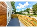 An exterior view of the side porch with blue concrete and wooden railing at 2724 N Dearborn St, Indianapolis, IN 46218