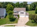Aerial view of a charming home with a lush backyard, spacious driveway, and mature trees at 3058 Mcintosh Dr, Bargersville, IN 46106