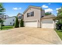 Side view of a home showcasing a three-car garage, driveway, and basketball hoop at 3058 Mcintosh Dr, Bargersville, IN 46106