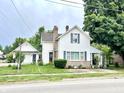 Charming two-story home with blue shutters, brick chimney, and covered side porch, set on a green lawn at 4096 N 200 W, Greenfield, IN 46140