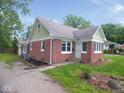 Side view of brick home with well-maintained lawn, showcasing the home's architecture at 4219 Mathews Ave, Indianapolis, IN 46227