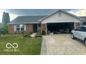 Charming brick home features an attached two-car garage and well-maintained lawn at 6334 Winslow Dr, Indianapolis, IN 46237