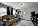 Cozy living room with modern gray sofa, plush throw blanket, and dark curtains at 725 2Nd St, Shelbyville, IN 46176