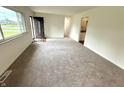 Spacious living room with newly installed carpet, neutral paint, and abundant natural light from the large window at 7301 E Wiser Ave, Camby, IN 46113