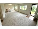 Bright living room with neutral carpet, white walls, and natural light streaming through large windows at 7301 E Wiser Ave, Camby, IN 46113
