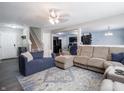 Open concept living room with plush sofas, a patterned rug, and seamless flow into dining and kitchen areas at 8125 Whistlewood Dr, Indianapolis, IN 46239