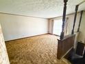 Spacious living room with carpet, vintage curtains, and wood trim at 906 Hemlock St, Shelbyville, IN 46176