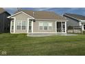 Spacious backyard with a stamped concrete patio, rear house elevation, and screened porch at 9404 Crystal River Dr, Indianapolis, IN 46240