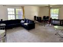 Bright and airy living room with neutral carpet, large windows, and a dark blue couch at 9621 Gemini Dr, Indianapolis, IN 46229
