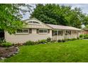 Quaint home featuring an attached garage and neatly landscaped front yard with decorative rock border and lush green grass at 10155 Orchard Park W Dr, Carmel, IN 46280