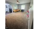 Spacious living room featuring plush carpeting, neutral paint, and large windows providing plenty of natural light at 1050 Laguna Ln, Greenwood, IN 46143