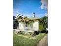 Side view of a bungalow featuring a front porch and a small, unkempt yard at 130 S Arlington Ave, Indianapolis, IN 46219