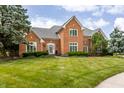 Beautiful brick home with a well-maintained lawn and mature trees in a suburban setting at 14030 Old Mill Ct, Carmel, IN 46032