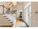 Elegant foyer features hardwood floors, a staircase with white railings, and decorative door at 14030 Old Mill Ct, Carmel, IN 46032