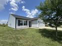 Well maintained lawn and landscaping surround this lovely home with a black roof at 1406 Bigleaf Cir, Sheridan, IN 46069